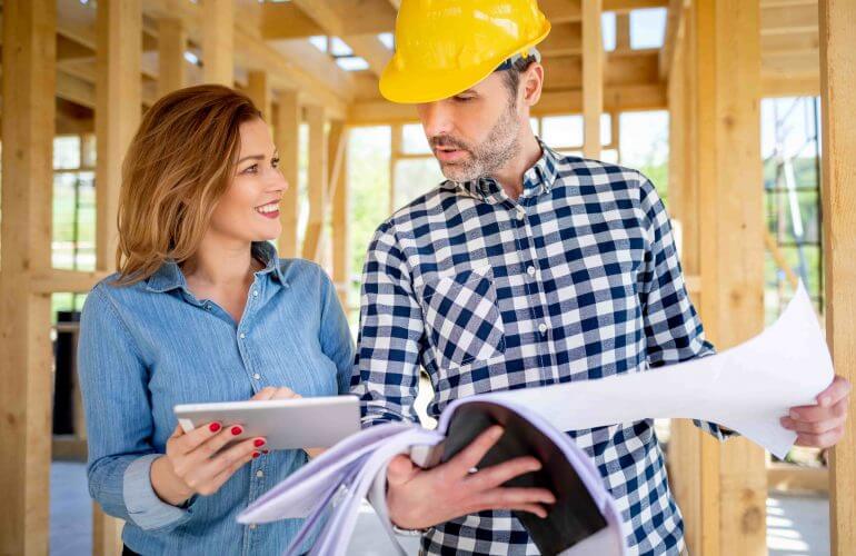 Female homeowner consults blueprints with Architec