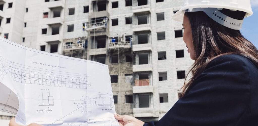 african-american-lady-safety-helmet-with-paper-plan-near-building-construction